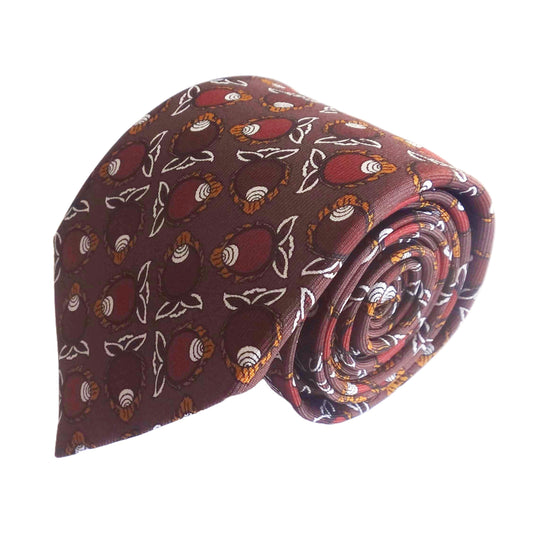 A rolled-up conch motif Rumi necktie with a brown base and a repeating pattern of conch motifs in shades of brown, set against a plain white background.