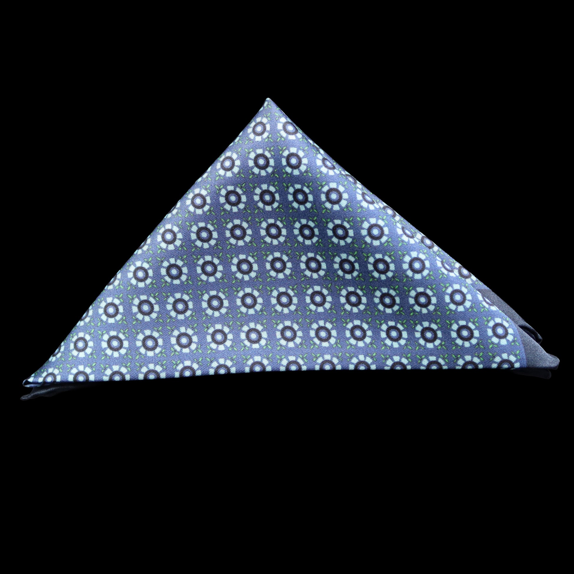 A blue pocket square with a repeating floral pattern in light blue, folded into a triangle and set against a solid black background.