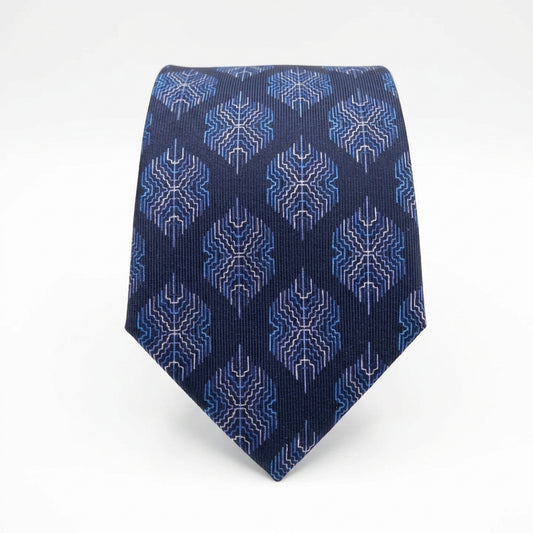 A classic necktie with a navy blue base and a repeating geometric pattern in shades of blue and white, displayed on a clean white background.