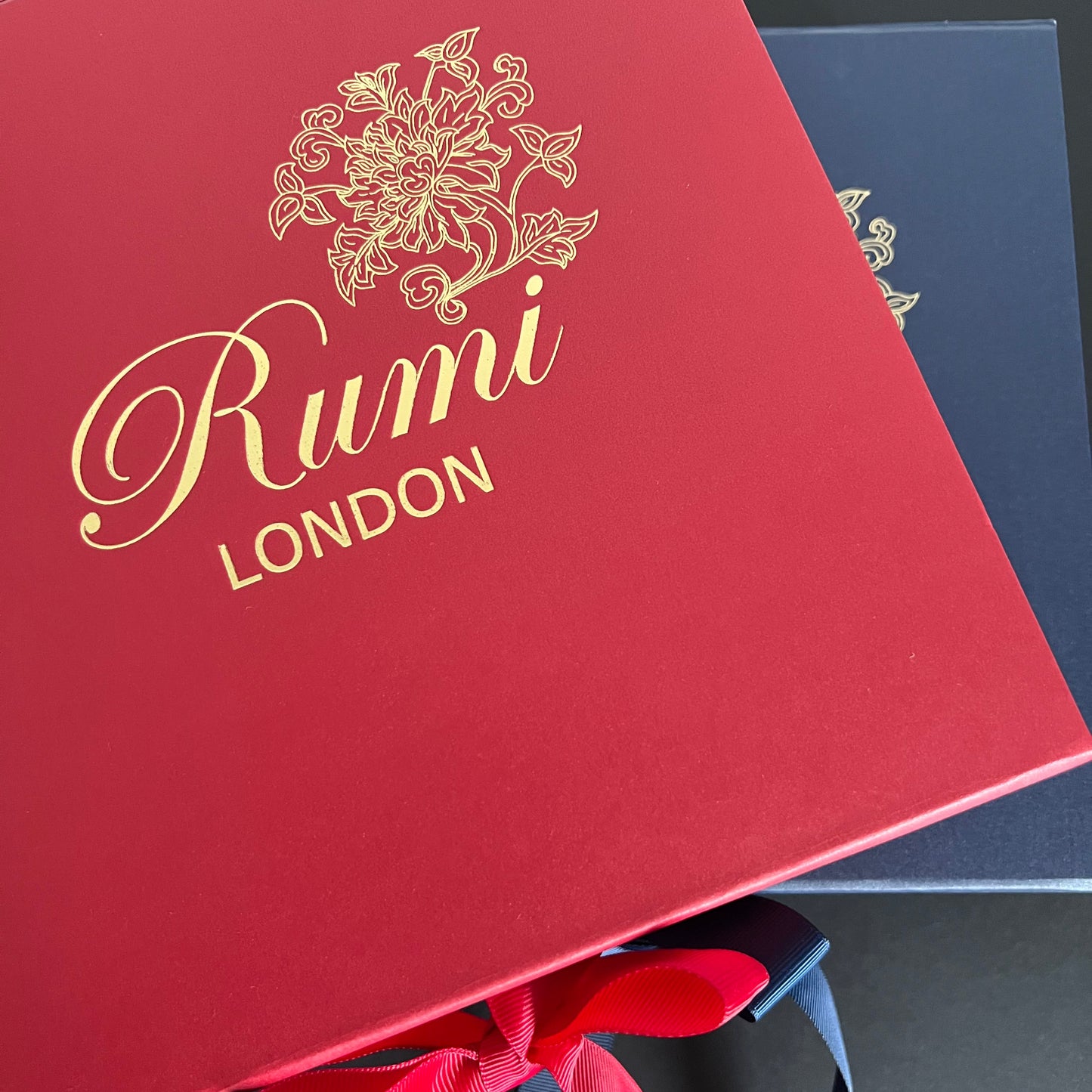 Red box with 'Rumi London' branding on a dark background