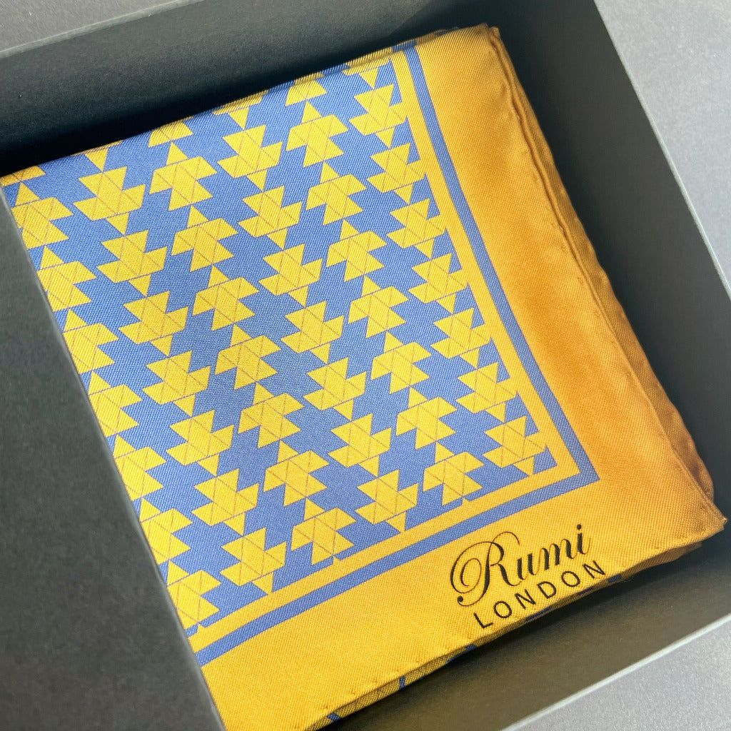 Folded Motif Square Silk Scarf in blue ad yellow in a black box.