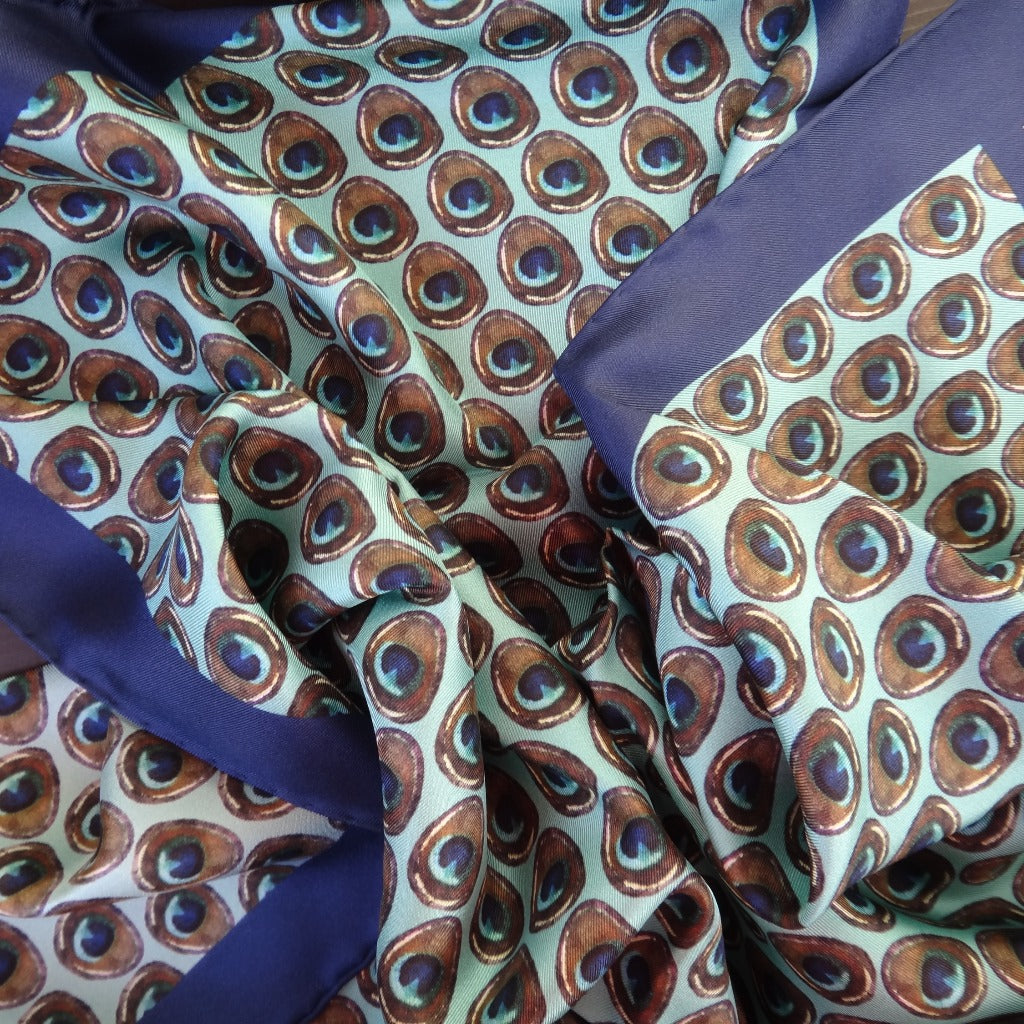 Pure silk blue and brown peacock feather print scarf on a turquoise base and with a blue border