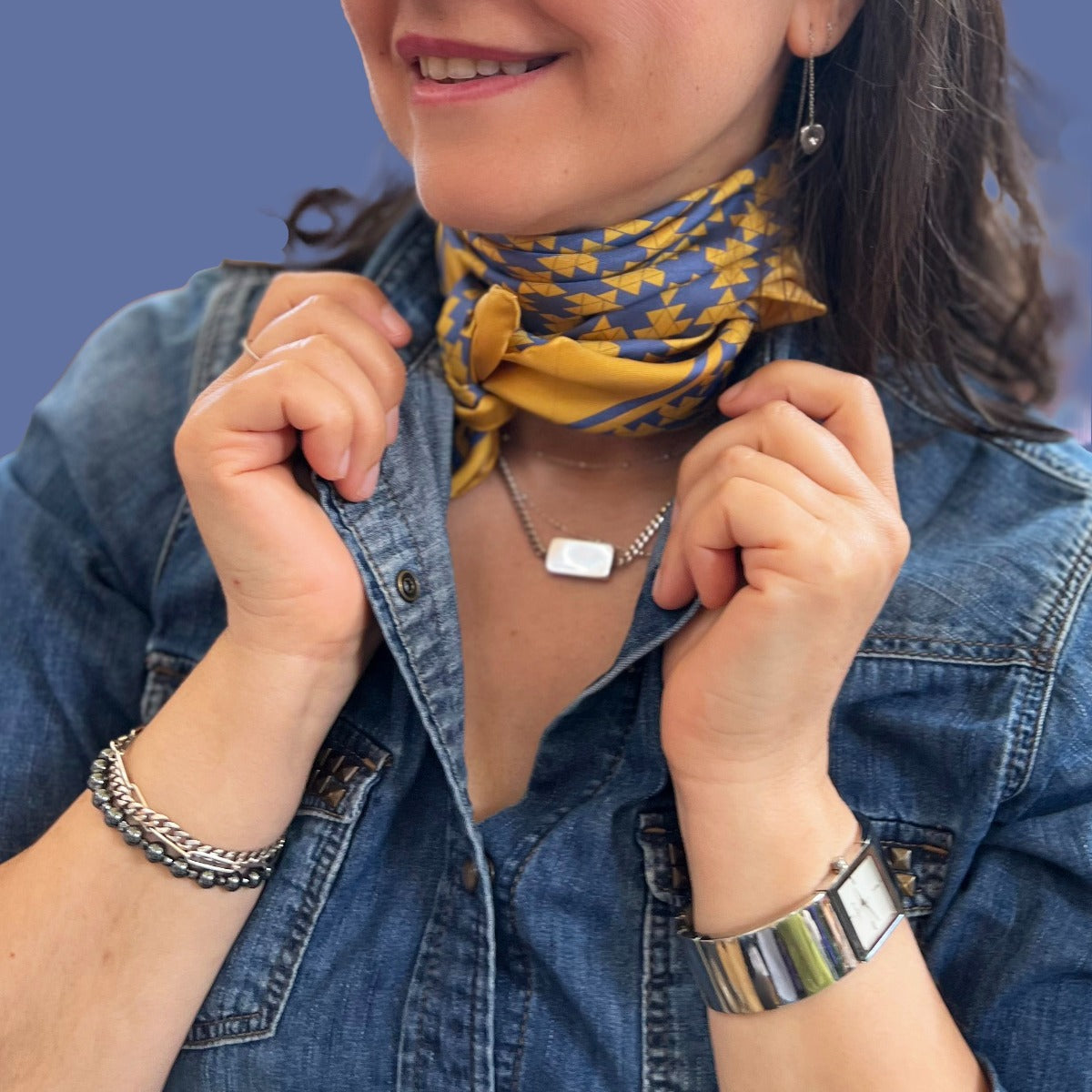 Patterned square silk scarf with blue and yellow geometric design on a yellow background, and branding 'Rumi London' in one corner.