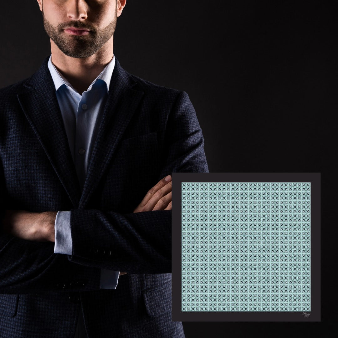 Man in a suit with a framed patterned floral pocket square on a black background